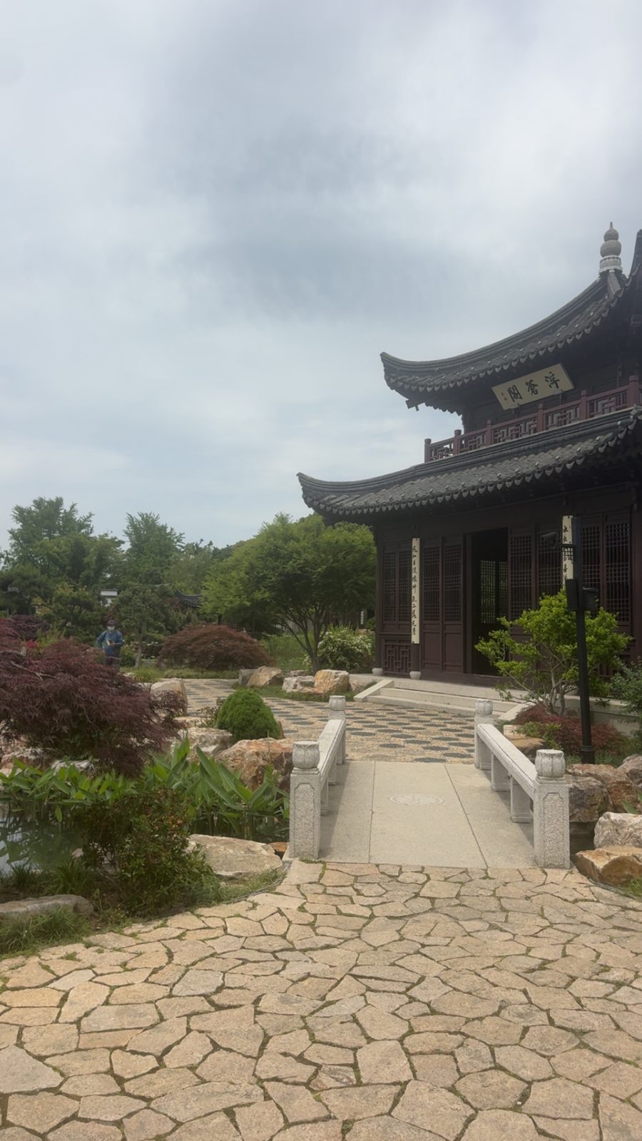 Stone bridge leading to a pavilion in a classical Chinese garden